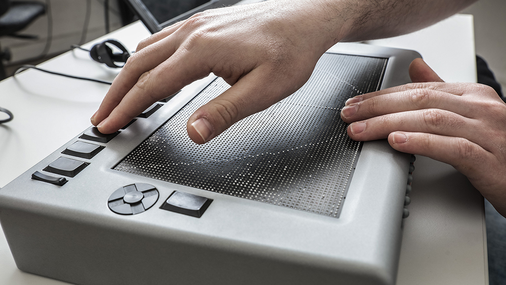 Das Foto zeigt zwei Hände, die das Hyperbraille bedienen.