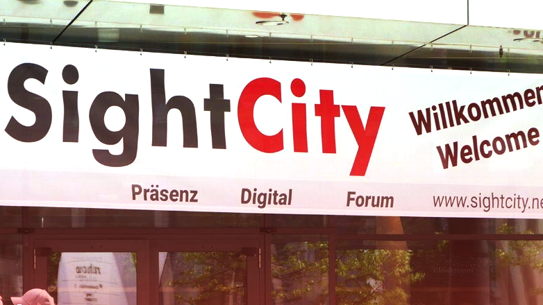 Das Foto zeigt einen Banner der SightCity, auf dem der Veranstaltungsname wie auch Willkommen sowie die Wörter Präsenz, Digital, Forum wie auch die Internetadresse aufgeführt ist.